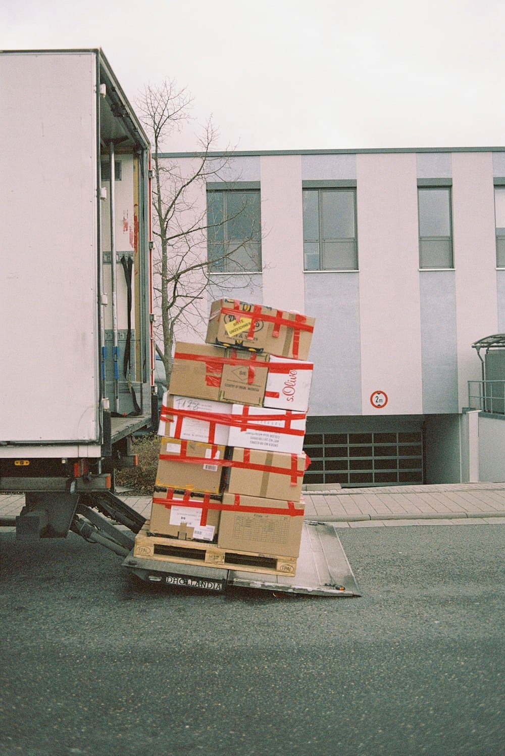 Taped moving boxes loaded onto a tail-lift van for a house removal