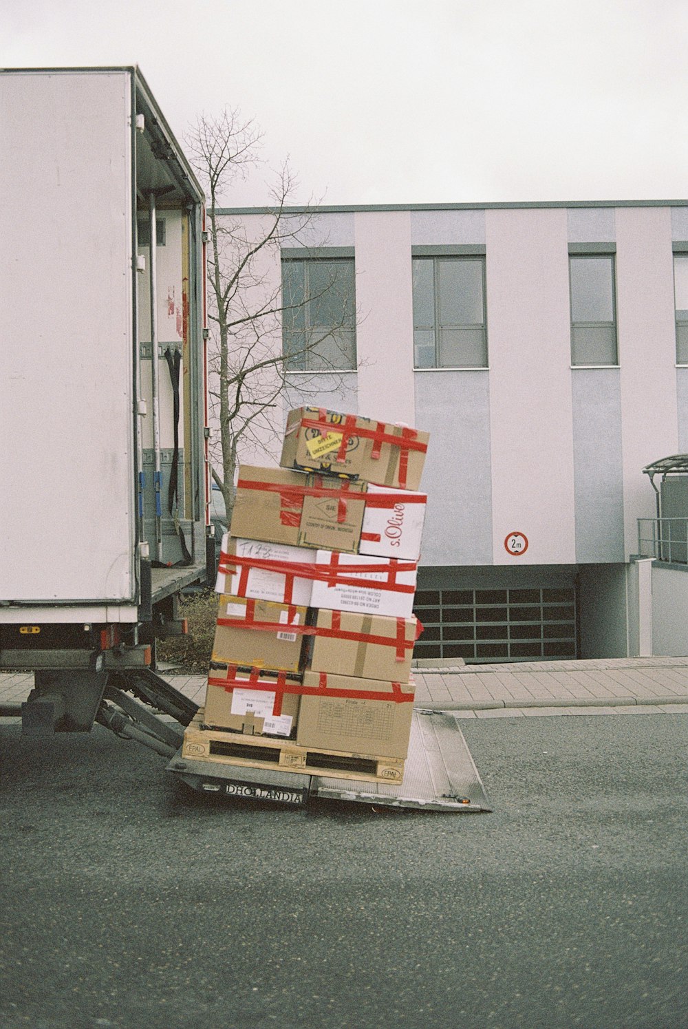 Taped moving boxes loaded onto a tail-lift van for a house removal